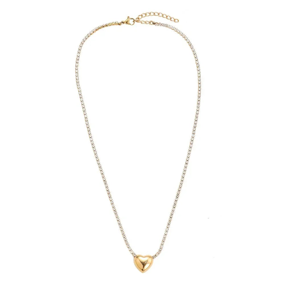 Zarte Halskette mit glitzernden Kristallen und goldenem Herzanhänger auf weißem Hintergrund