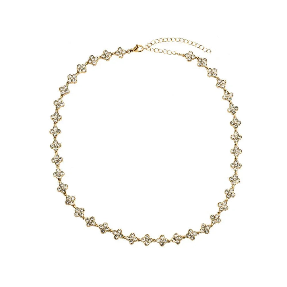 Elegante goldfarbene Halskette mit kleinen, blumenförmigen Strasssteinen auf weißem Hintergrund