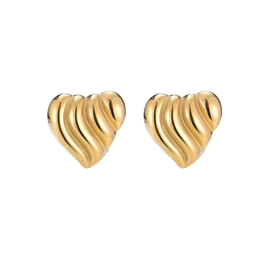 Goldene Herz-Ohrstecker mit geschwungenem Design auf weißem Hintergrund