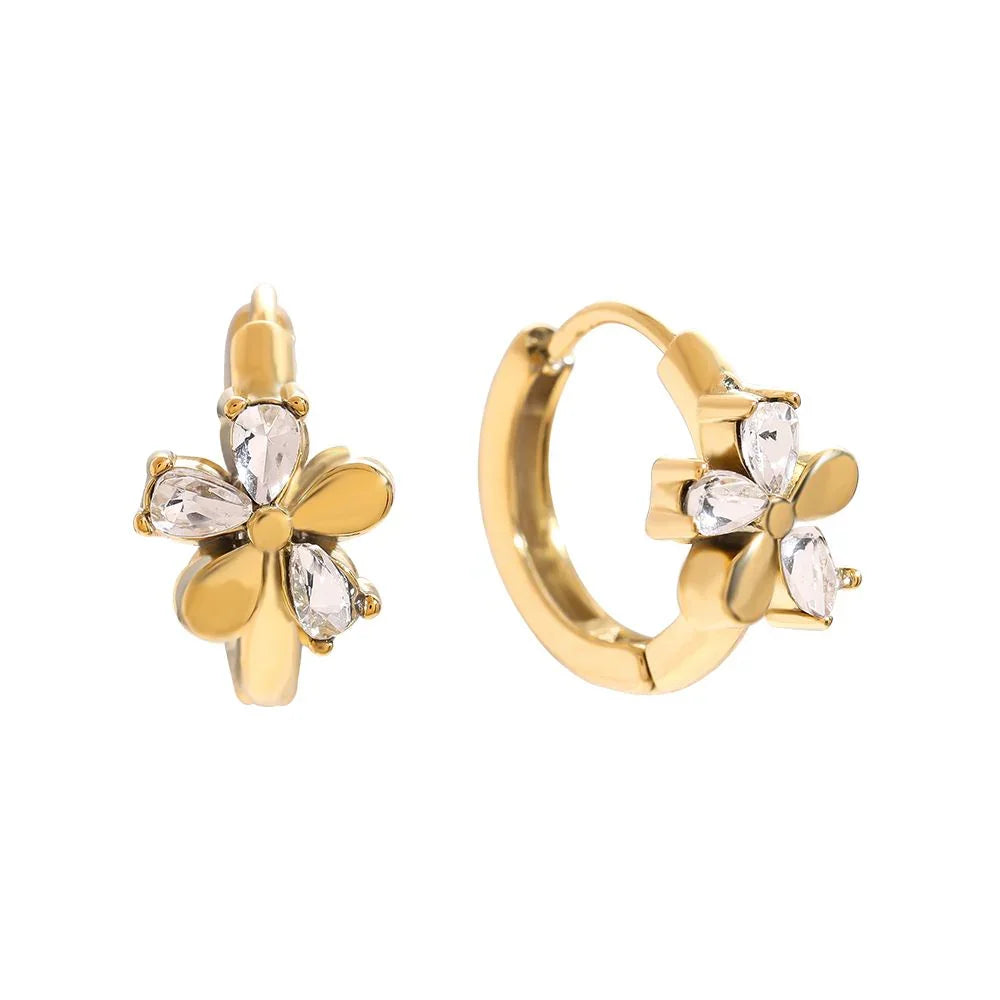 Goldene Creolenohrringe mit Blütenmotiv und klaren Tropfensteinen auf weißem Hintergrund