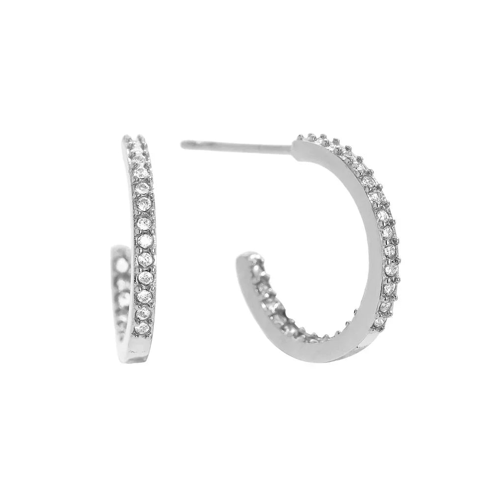 Silberne Halbcreolen Ohrringe mit funkelnden Kristallen auf weißem Hintergrund