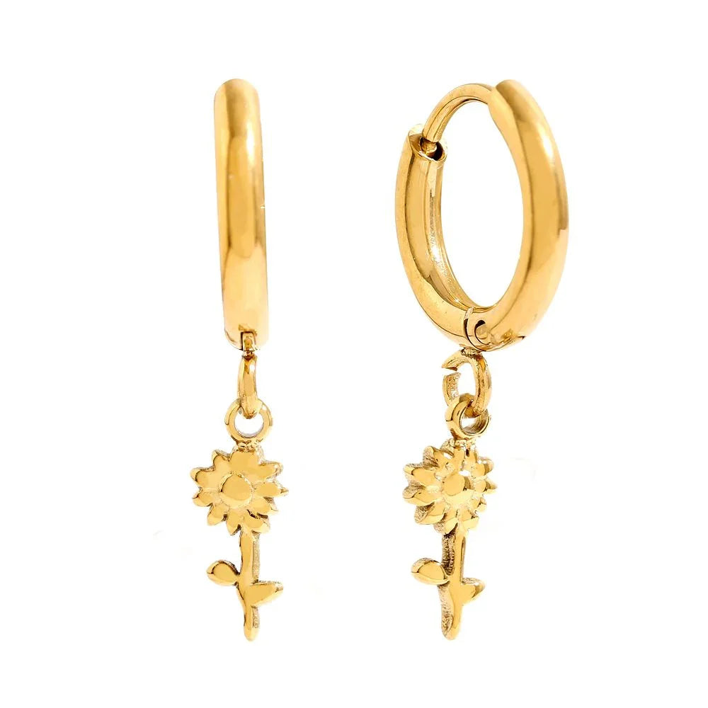 Goldene Creolen-Ohrringe mit Sonnenblumen-Anhänger auf weißem Hintergrund