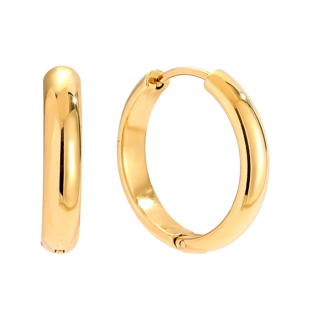 Elegante goldene Kreolenohrringe mit glänzender, glatter Oberfläche vor weißem Hintergrund