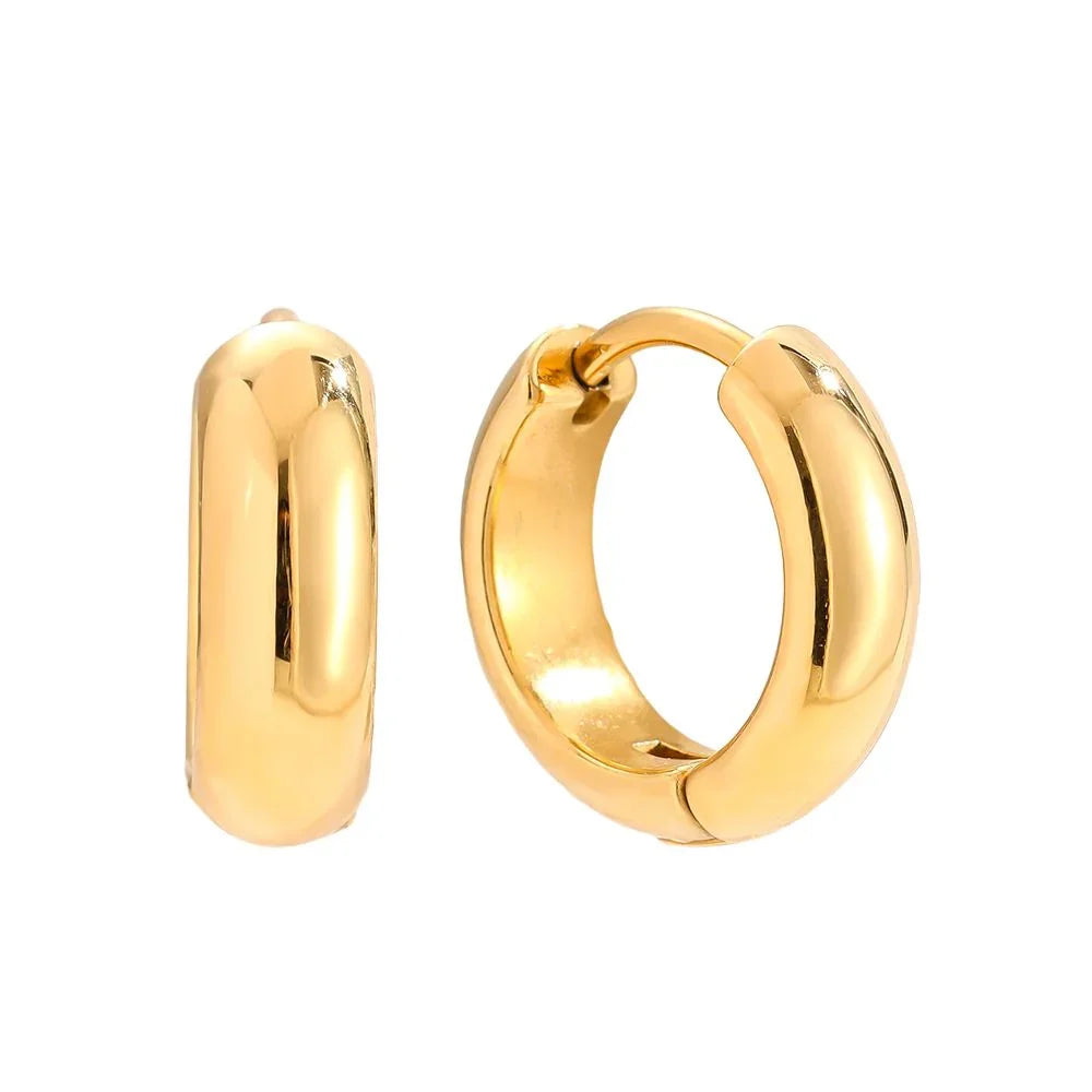 Glänzende goldene Creolen Ohrringe mit polierter Oberfläche vor weißem Hintergrund