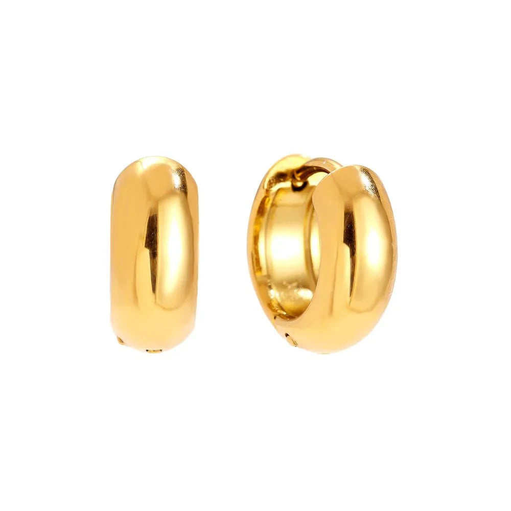 Glänzende goldene Creolen Ohrringe auf weißem Hintergrund