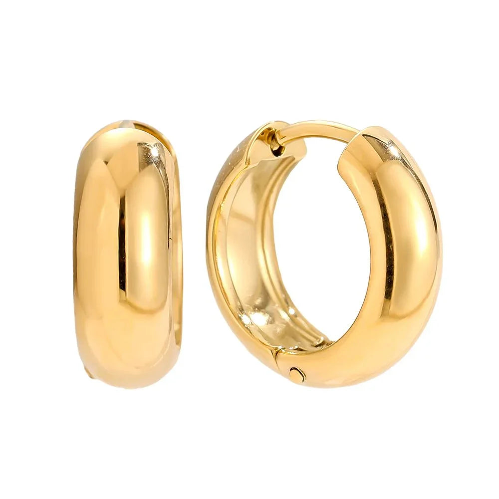 Glänzende goldene Creolen-Ohrringe aus glänzendem Metall auf weißem Hintergrund