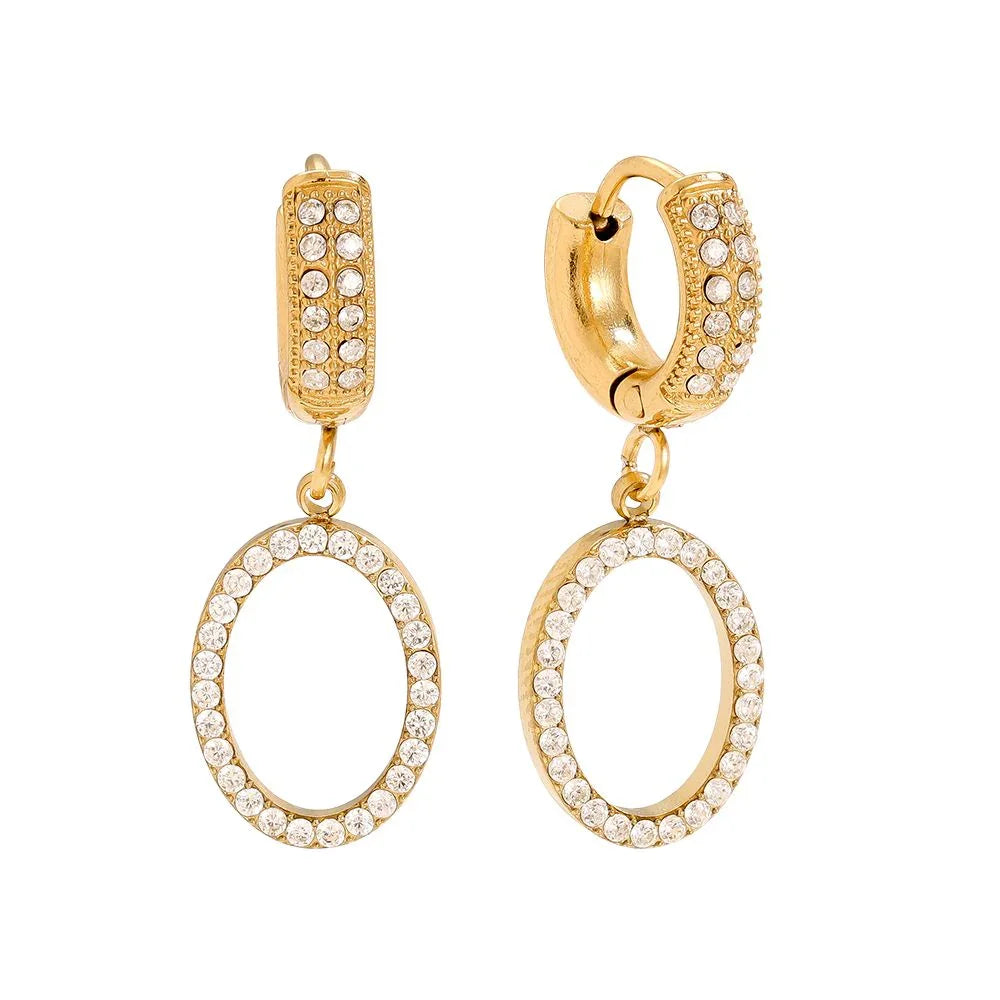 Goldene Creolen Ohrringe mit funkelnden Kristallen und ovalen Anhängern vor weißem Hintergrund