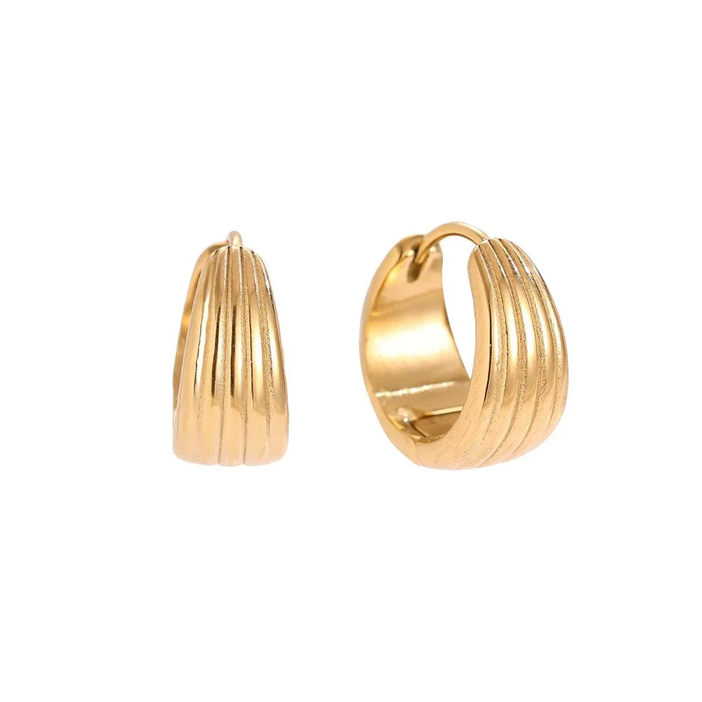 Goldene Creolen Ohrclips mit gerilltem Design auf weißem Hintergrund