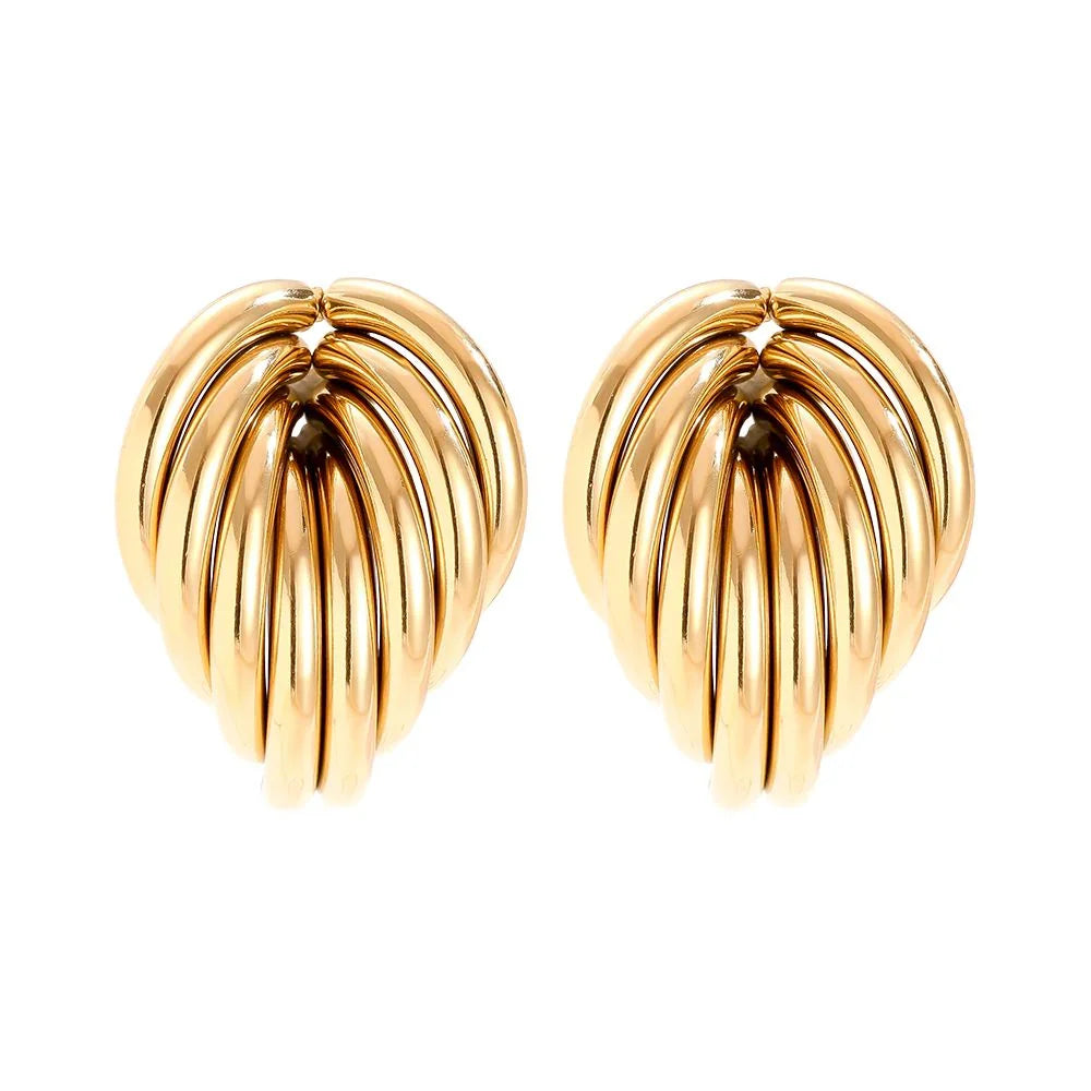 Goldfarbene, muschelförmige Ohrringe aus glänzendem Metall auf weißem Hintergrund
