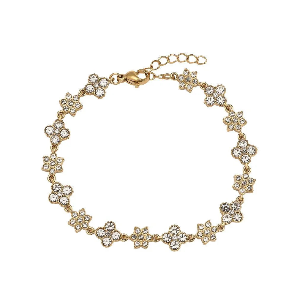 Goldfarbenes Armband mit blumenförmigen Kristallverzierungen auf weißem Hintergrund