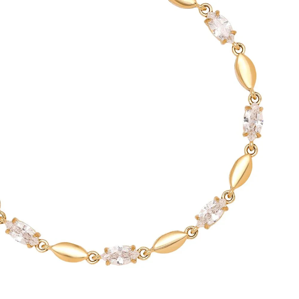 Elegantes goldfarbenes Armband mit klaren, ovalen Kristallsteinen auf weißem Hintergrund