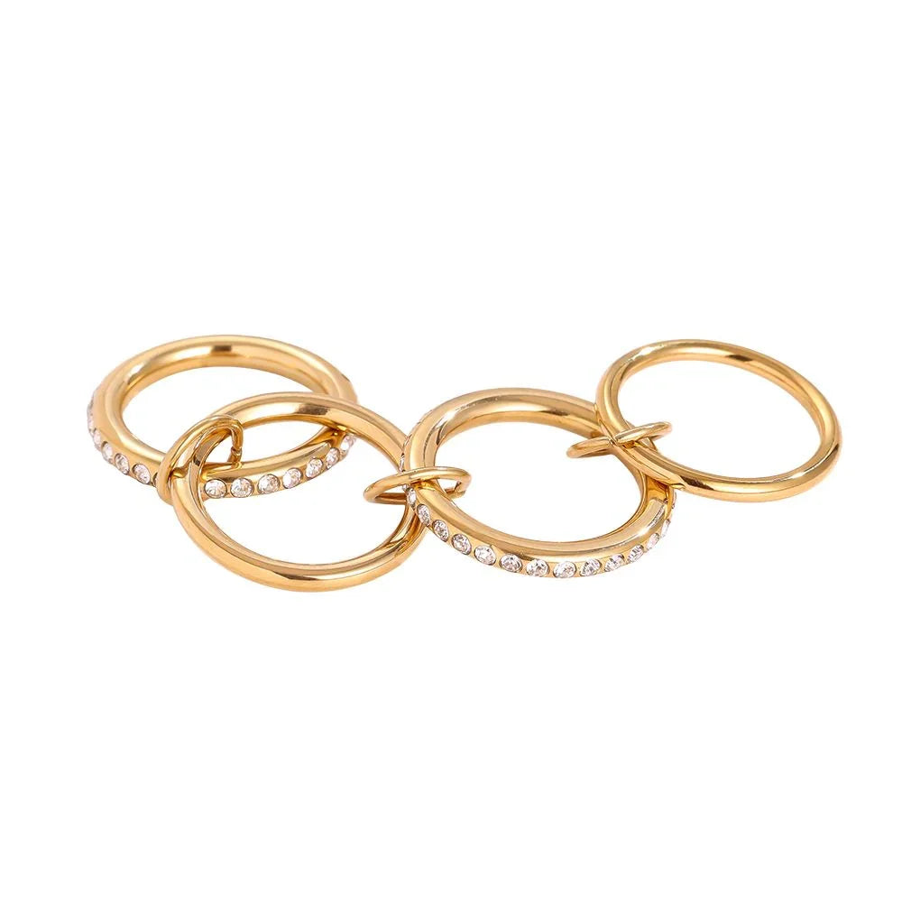 Goldfarbene Ringe mit Kristallbesatz in einem modernen Design auf weißem Hintergrund