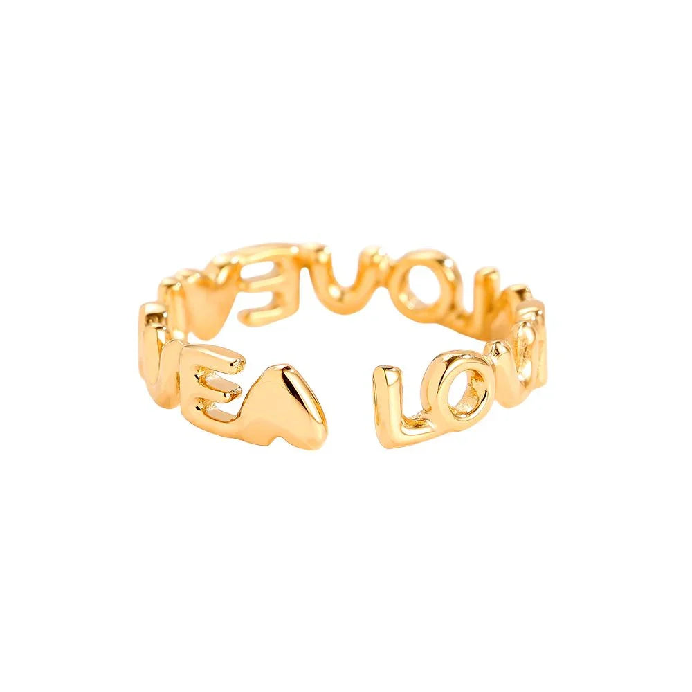 Goldfarbener Statement-Ring mit dem Schriftzug LOVE und Herzmotiv auf weißem Hintergrund