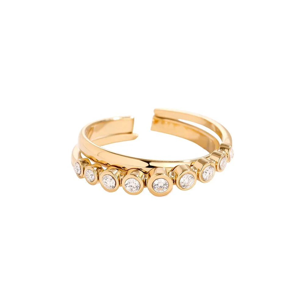 Offener goldener Ring mit neun runden klaren Diamanten in Fassungen auf weißem Hintergrund