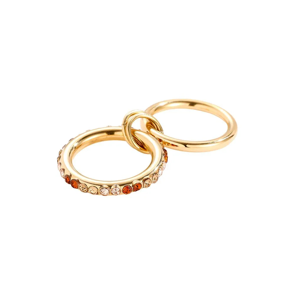 Goldene Creolen mit Strasssteinen in Braun- und Beigetönen auf weißem Hintergrund