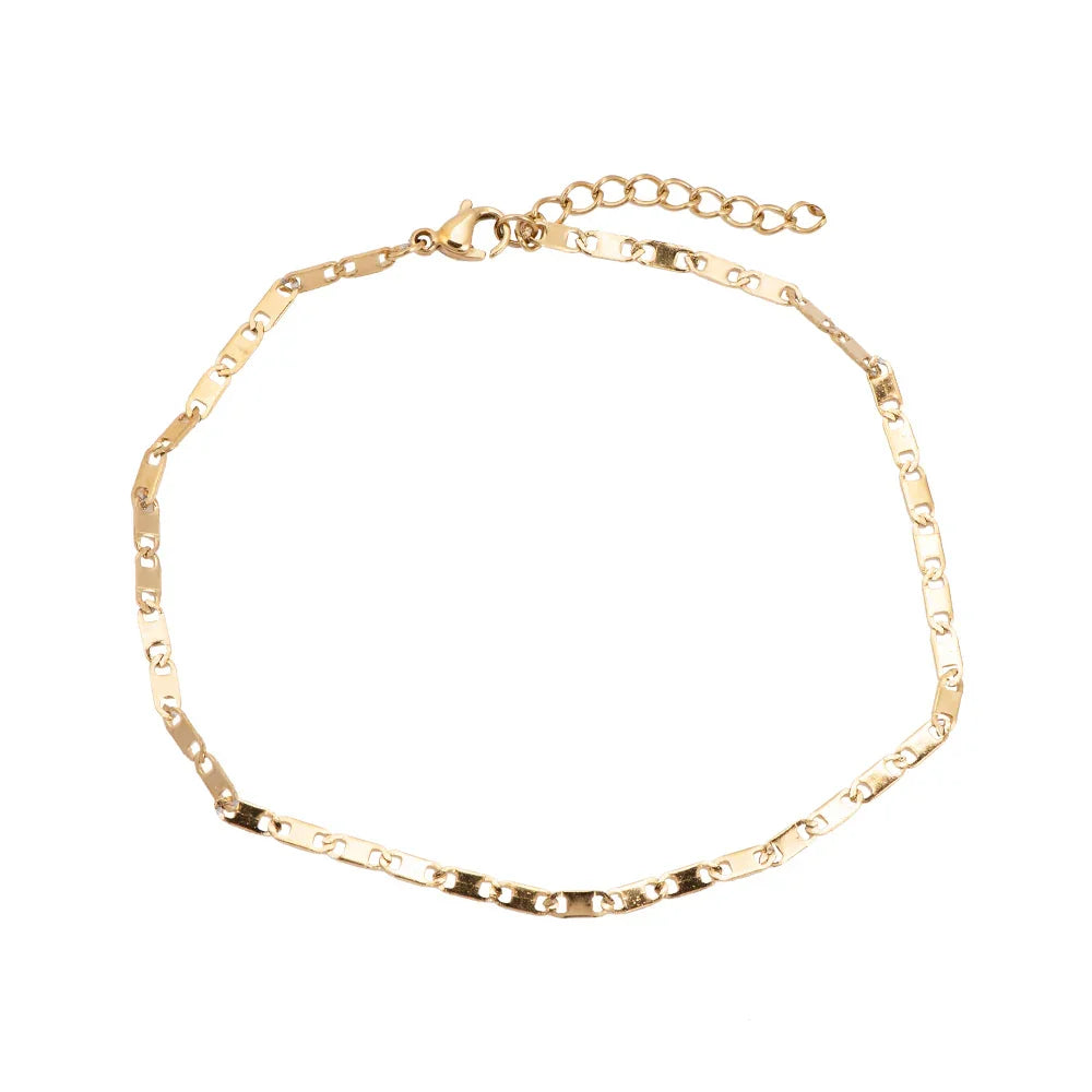 Feine goldene Gliederkette mit Karabinerverschluss auf weißem Hintergrund